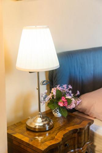 a table with a lamp and flowers on it at Collina Blu in Orvieto