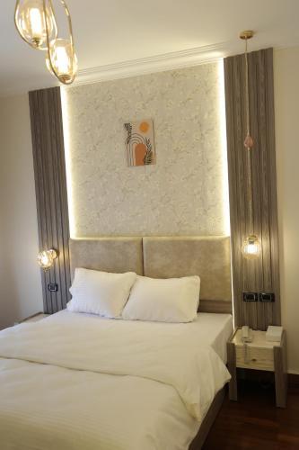 a bedroom with a large bed with white pillows at Gold Palace Hotel in Cairo