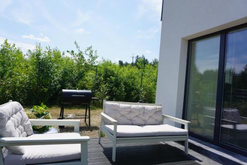 two chairs sitting on a deck next to a window at La Jura in Podlesice