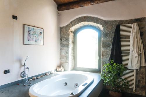 a bathroom with a large tub and a window at Collina Blu in Orvieto