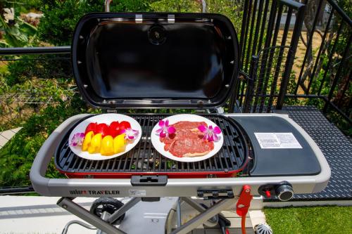a grill with two plates of food on it at 最大18名OK 南城市 百名の大型貸別荘 BBQ ビーチ近くでグループ滞在に最適 Seaside House Ichika in Nanjo