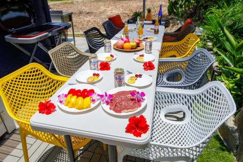 a white table with plates of food on it at 最大18名OK 南城市 百名の大型貸別荘 BBQ ビーチ近くでグループ滞在に最適 Seaside House Ichika in Nanjo