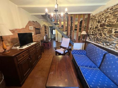 a living room with a couch and a tv at La Casona del Cura 2, LIRIO in Pravia