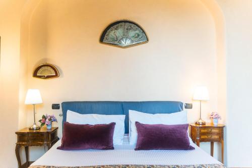 a bedroom with a bed with two purple pillows at Collina Blu in Orvieto