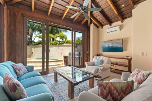 un salon avec des chaises bleues et une table en verre dans l'établissement Las Catalinas Villa 5 BD, à Playa Danta