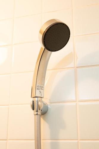 a shower head in a bathroom with white tiles at Private house 100sqm with bicycles Disney 30min in Tokyo