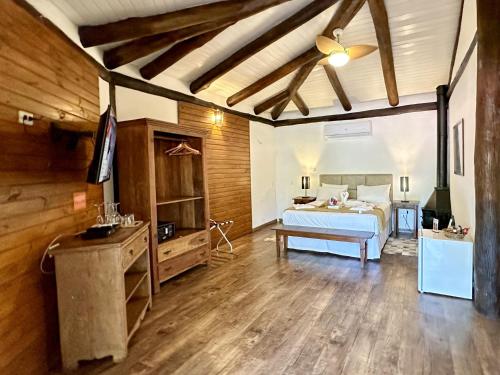 a bedroom with a bed and a wooden floor at Ilha de Toque Toque Eco Hotel in São Sebastião