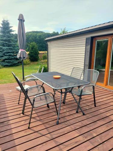 a table and chairs on a deck with an umbrella at Ubytování na vsi in Dvůr Králové nad Labem