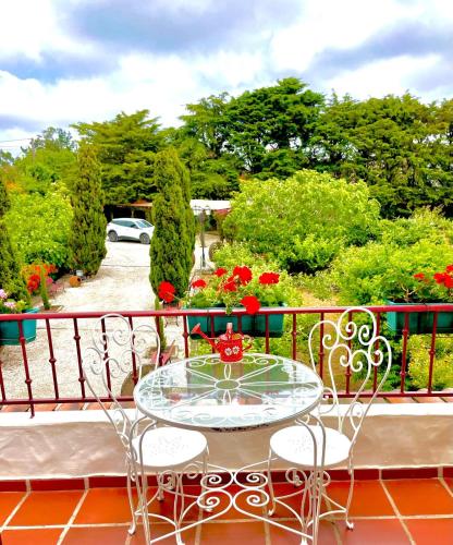a glass table and chairs on a balcony at Alto Paraíso Boutique Hotel in Reguengo Grande