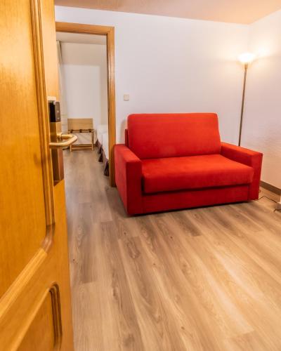 a red couch sitting in a room with a wooden floor at Pacoche Murcia in Murcia