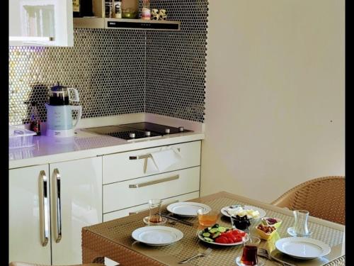 a kitchen with a table with plates of food on it at MODA MARİNE LUXURY HOMEs in Alanya