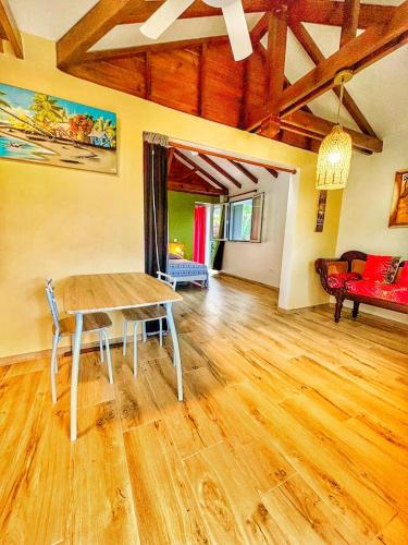 a living room with a wooden table and a couch at Ti Ben - Jacuzzi Privatif Jardin Tropical - Le Robert in Le Robert