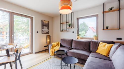 a living room with a couch and a table at Apartamenty z basenem i saunami STONE HILL RESORT II VIP Centrum by Royal Aparts in Szklarska Poręba