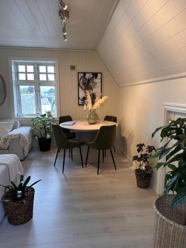 a living room with a table and chairs in a room at Cozy top floor apartament in Stavanger