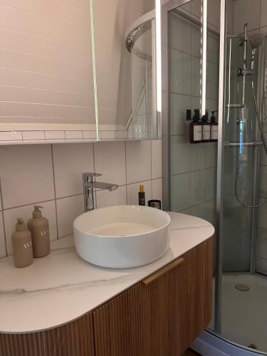 a bathroom with a white sink and a shower at Cozy top floor apartament in Stavanger