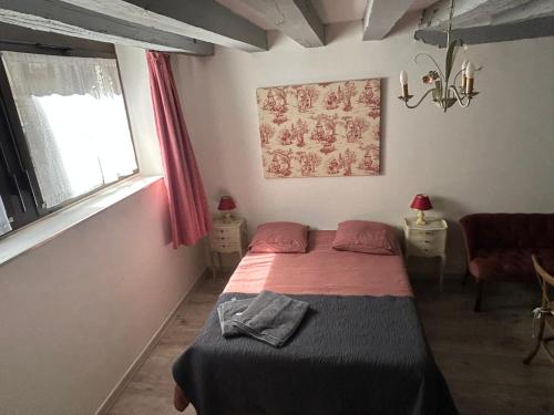 une petite chambre avec un lit et une fenêtre dans l'établissement Le logis de l'hermine, à Blois