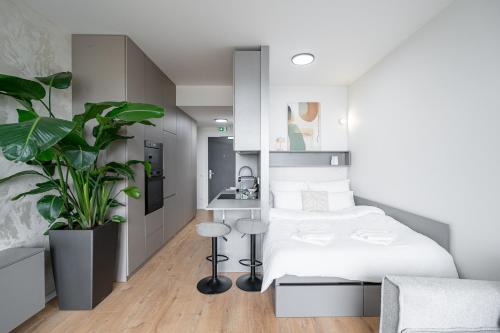 a bedroom with a white bed and a plant at Work&Living Studio-Prístavná1 in Nivy