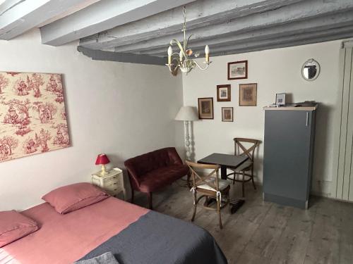 une chambre avec un lit, une table et une chaise dans l'établissement Le logis de l'hermine, à Blois