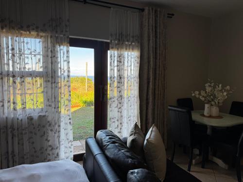 a living room with a couch and a large window at The olive stay at Edwardian unit F7 in Port Edward