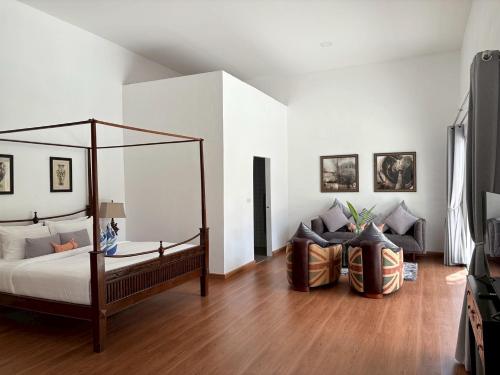 a bedroom with a canopy bed and a couch at Tropical Garden Luxury Villa, Koh Phangan in Koh Phangan