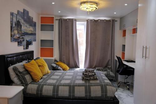 a bedroom with a bed with yellow pillows and a window at Tina guest house in London