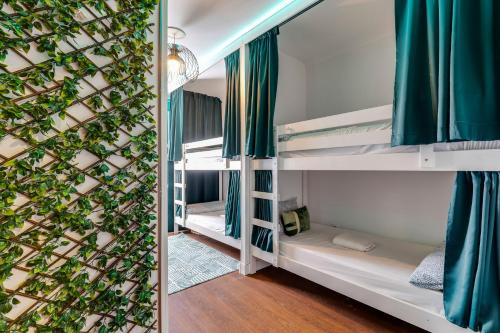 a room with bunk beds and a wall with a plant at Casa da Música Guesthouse in Porto