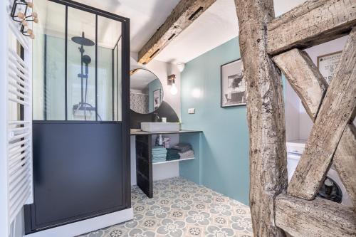 a bathroom with a glass shower and blue walls at Duplex cosy centre historique in Limoges