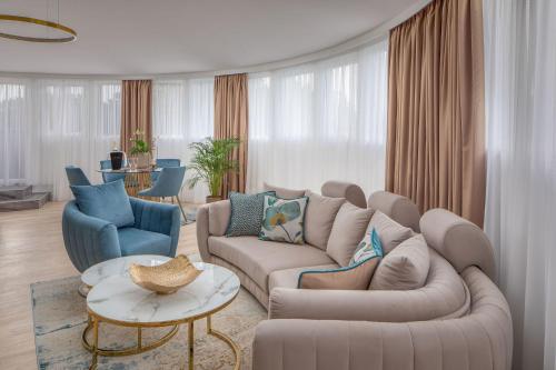 a living room with a couch and two chairs at Lotus Therme Hotel & Spa in Hévíz