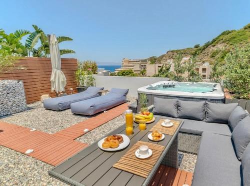 a patio with a table with food and a pool at Sunny Nest Apartments in Ixia