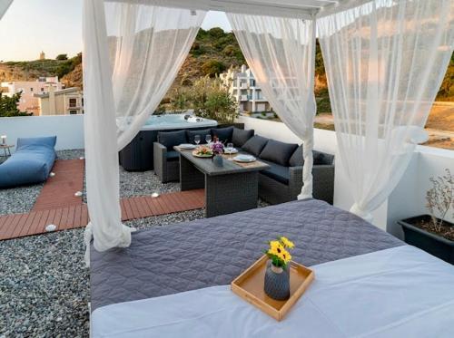 a bedroom with a bed and a patio with a table at Sunny Nest Apartments in Ixia