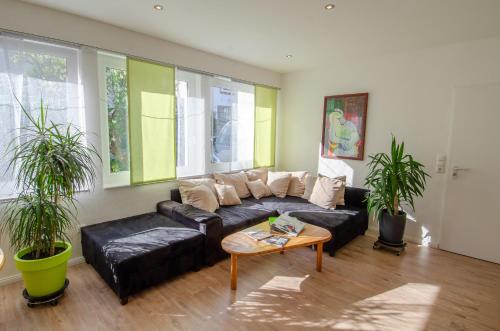a living room with a black leather couch and a table at Haus Sieber in Schiltach