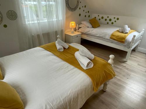 two beds in a bedroom with towels on them at Atlantic View Cottage in Mountnugent