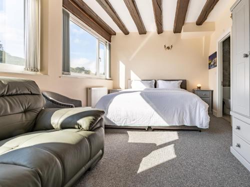 a bedroom with a bed and a couch at 4 Bed in Bala 75288 in Llandderfel