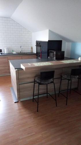 a kitchen with a counter with two chairs and a counter top at Lila Apartment in Braslovče
