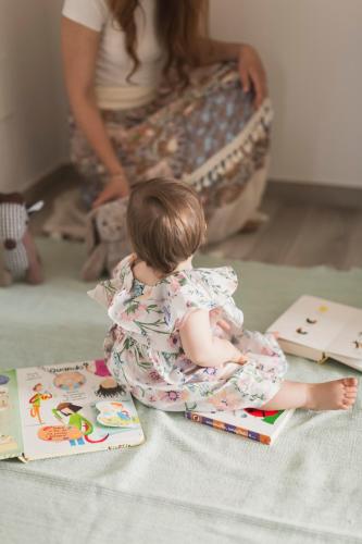 a baby sitting on the floor reading a book at Casa Ferrant in Faloppio