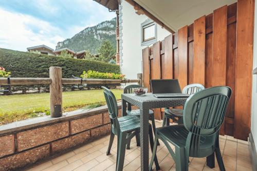 a patio with a table and chairs with a laptop on it at Aparthotel Majestic in Predazzo