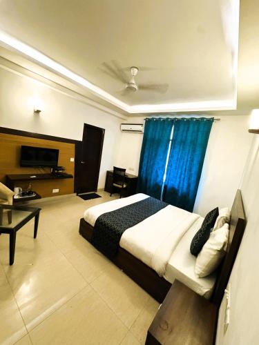 a bedroom with a bed with a blue curtain at Tavisha Villa Film City Road Dadri Road in Noida
