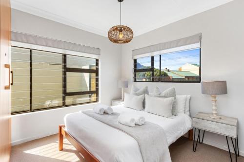 Un dormitorio blanco con una cama y una ventana. en 8 on Nivenia by Host Agents, en Bettyʼs Bay