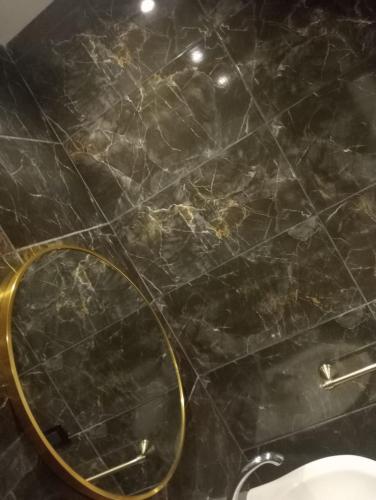 a bathroom with a black marble floor with a mirror at Time Off in Alexandria