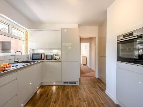 a kitchen with white cabinets and a wooden floor at 2 bed in Poole 85399 in Lytchett Matravers