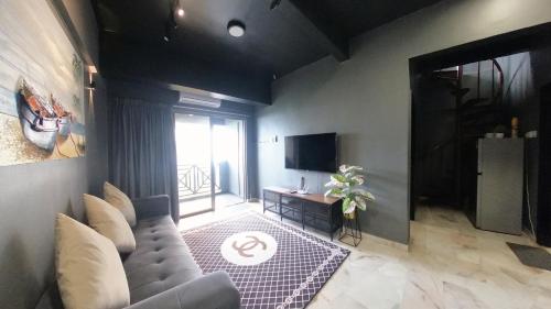a living room with a couch and a television at 13pax BAYU EXECUTIVE SUITE 3R2B, SEASIDE, ROOFTOP BBQ, WATERSPORT, Pool, Wifi, 50"TV in Port Dickson