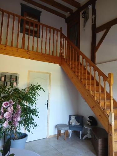 a wooden staircase in a living room with a plant at La cabane de Lancelot Chambre Campagne in Laperrière-sur-Saône