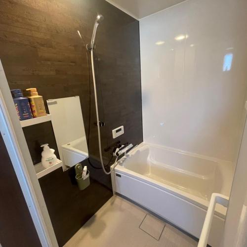 a bathroom with a shower and a tub and a sink at OSAKA FUJI STAY namba in Osaka