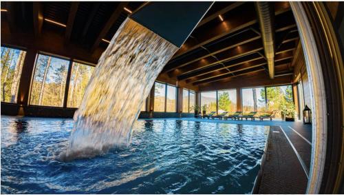 a large swimming pool with a water fountain at Drevenica Desina in Terchová