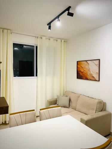 a living room with a couch and a window at Apartamento Ponta de Campina, 500m da Praia, com Vista Incrível do Pôr do Sol in Cabedelo