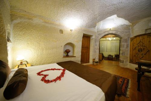 a bedroom with a bed with a red flower on it at Harman Cave Hotel in Goreme
