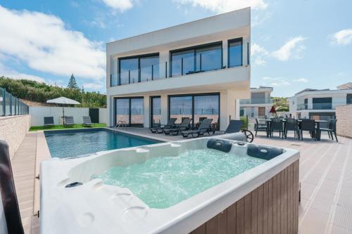 a house with a large bath tub in the backyard at Dino Villa with ocean view in Casal do Cigano