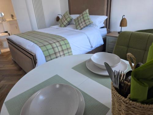 a room with a bed and a table with a plate on it at Musselburgh Links B&B in Musselburgh