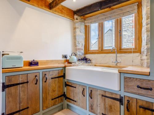 a kitchen with wooden cabinets and a white sink at 2 Bed in Glastonbury 79122 in Glastonbury
