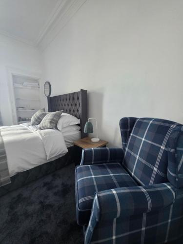 a bedroom with a bed and a couch and a chair at Musselburgh Links B&B in Musselburgh